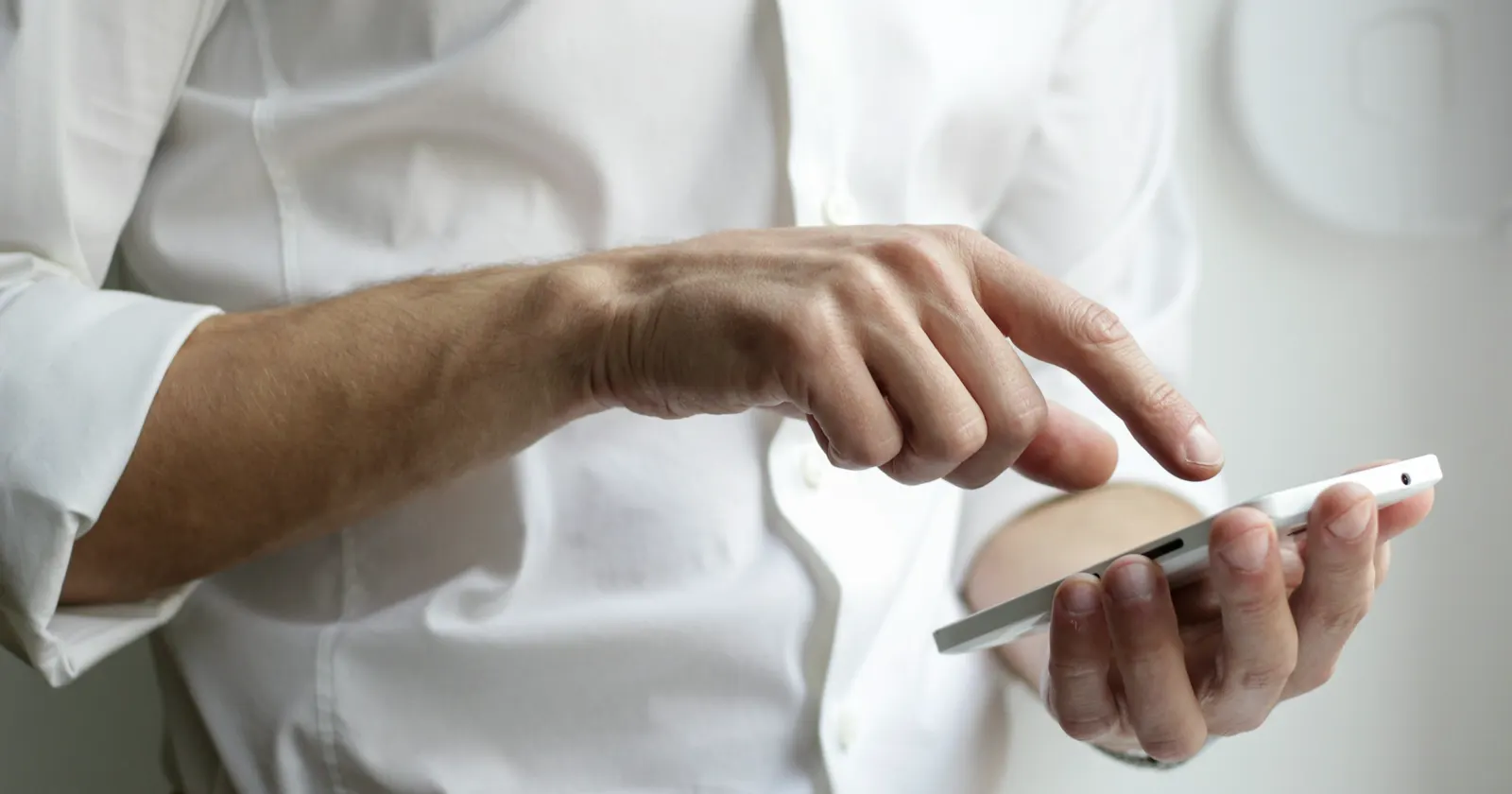 A person holding a smartphone and tapping the screen